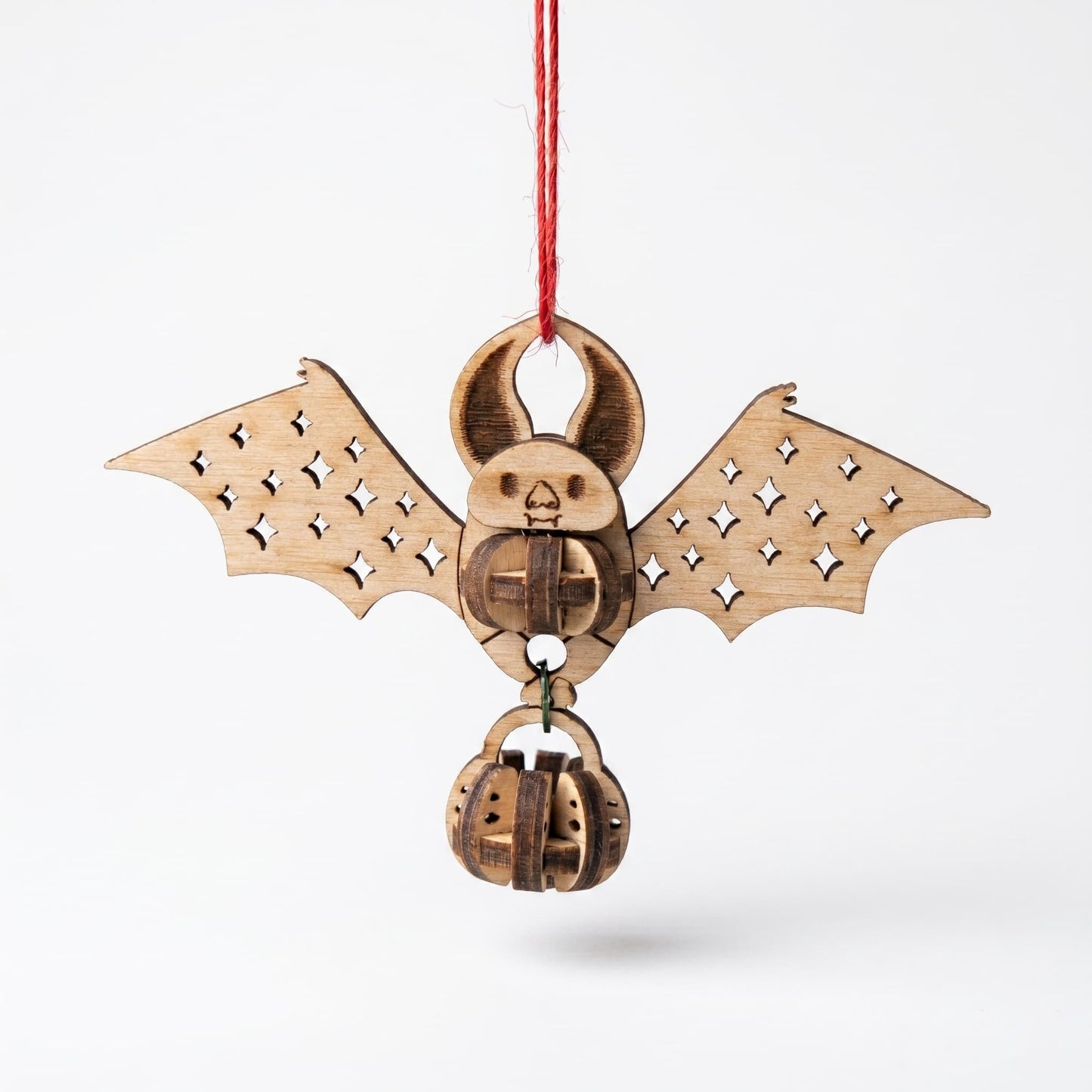 Wooden bat-shaped laser cut ornament with pumpkin design on a white background
