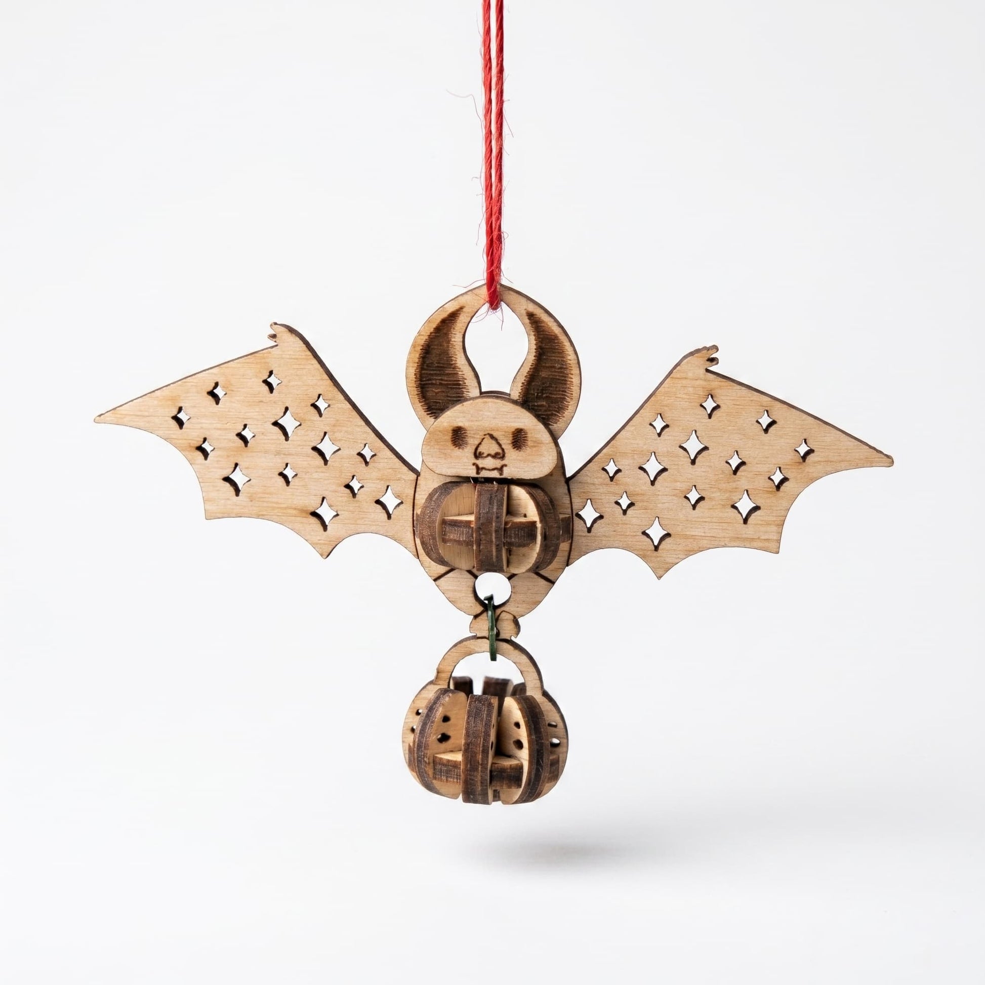 Wooden bat-shaped laser cut ornament with pumpkin design on a white background
