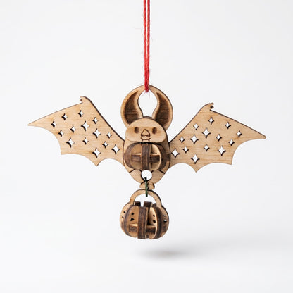 Wooden bat-shaped laser cut ornament with pumpkin design on a white background