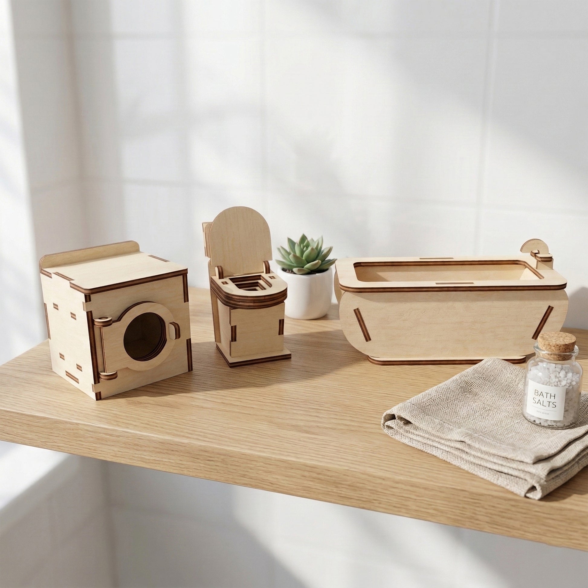 Miniature dollhouse bathroom set made of laser cut plywood. The set includes a tiny bathtub, a sink with a mirror, and a toilet. Natural wood texture with precise details, shown in a 1:12 scale dollhouse setting.