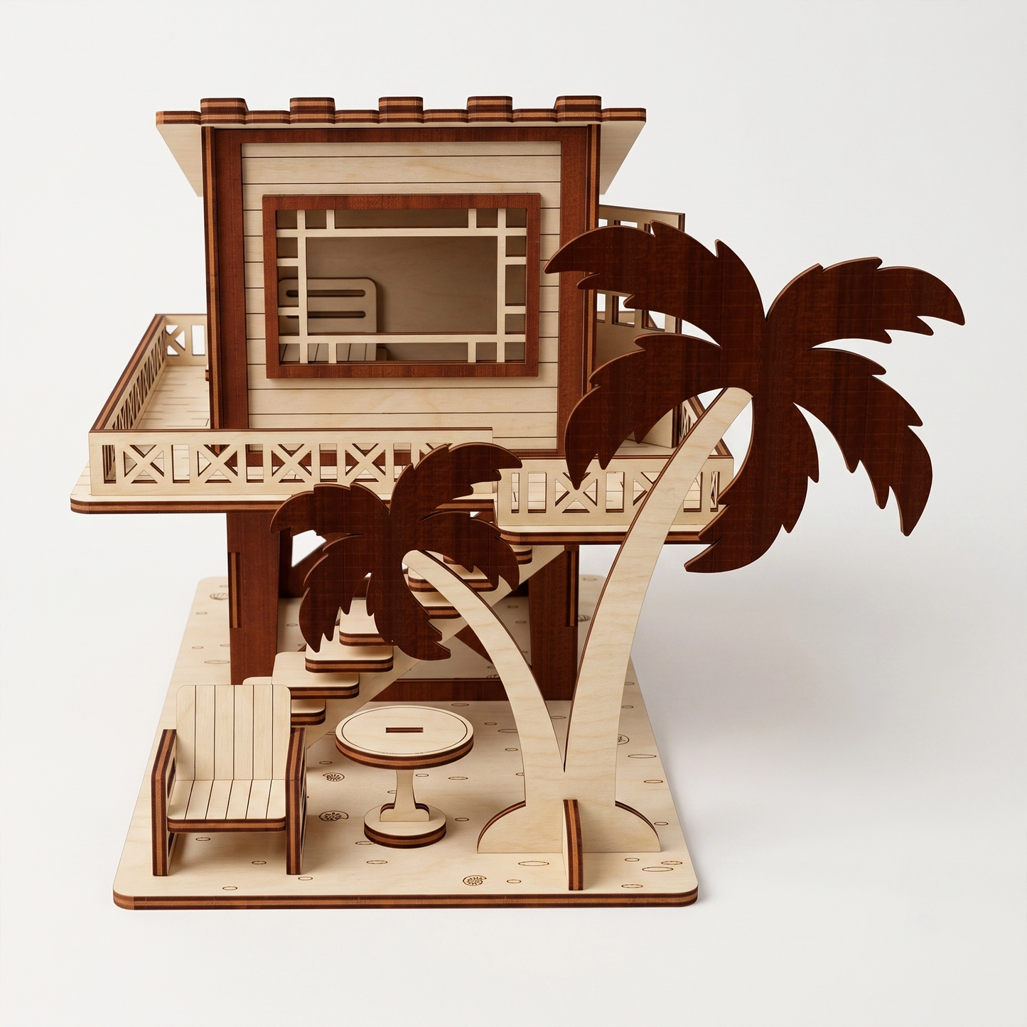 Front-facing studio view of a laser-cut birch plywood beach house model with palm trees, outdoor furniture, and stairs.