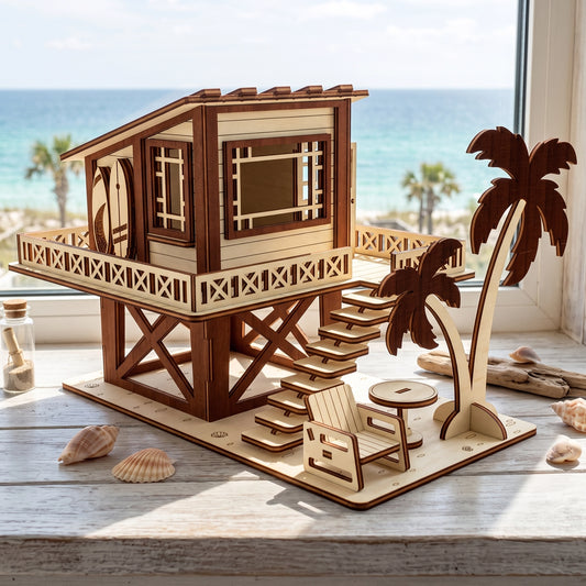 Laser-cut birch plywood beach house model displayed on a windowsill with sea view, seashells, and sand in a glass bottle