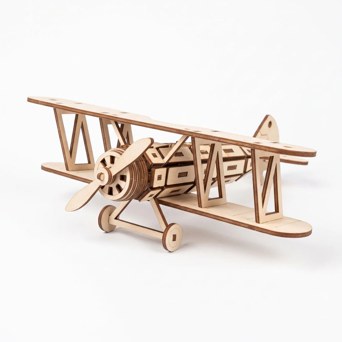 A wooden laser cut model of a biplane, with a propeller and two wings, is shown against a white background.