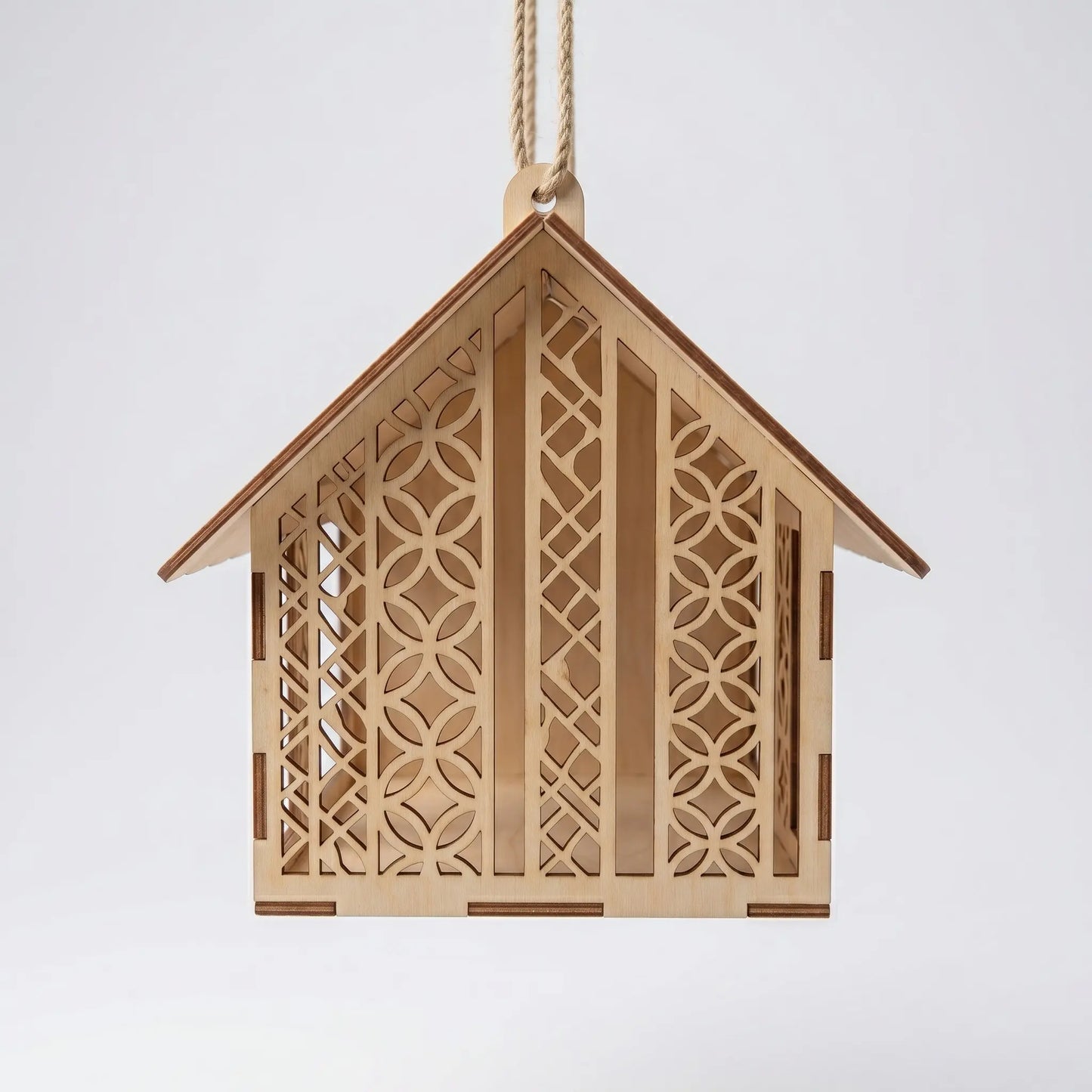 Wooden birdhouse with intricate cut-out patterns on a white background