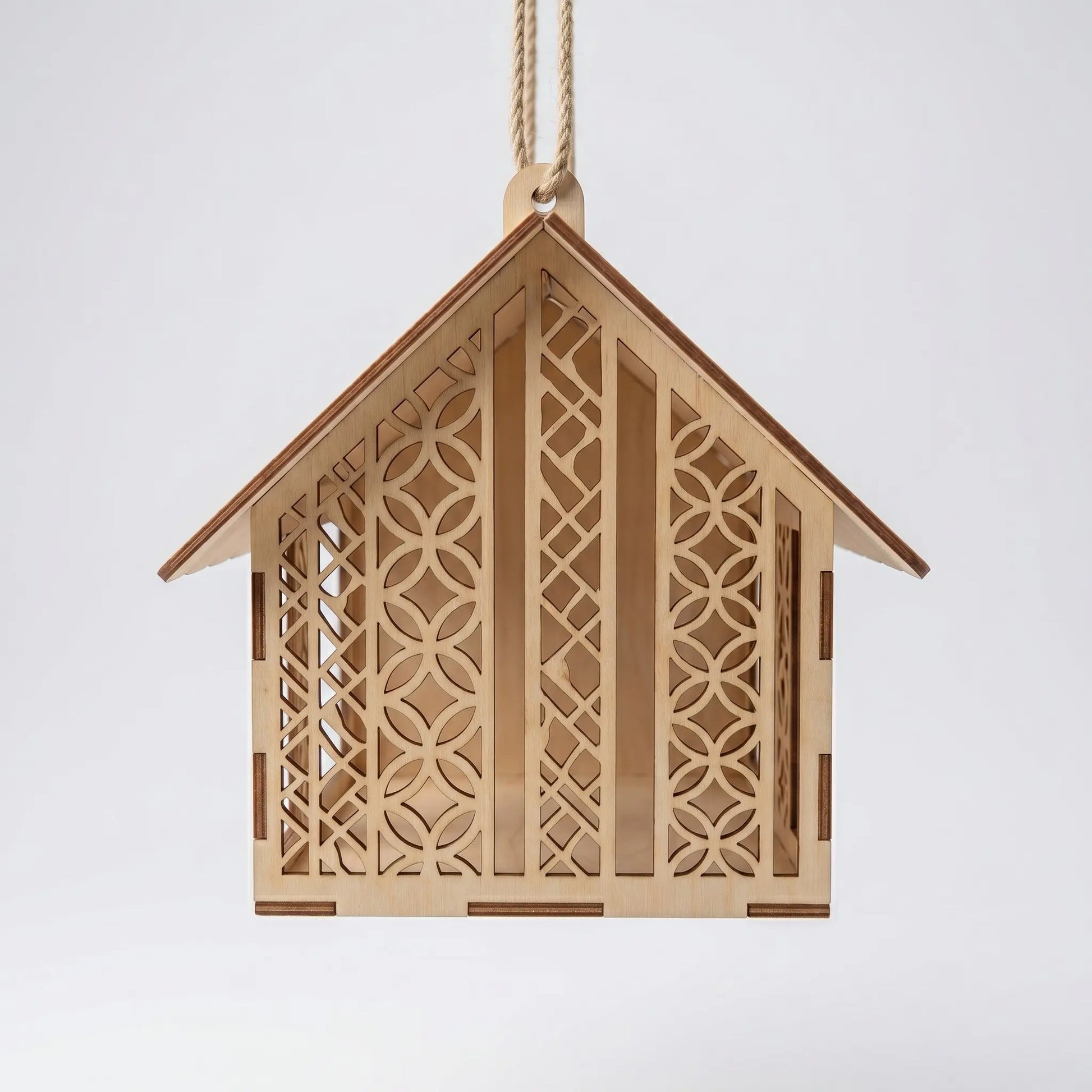 Wooden birdhouse with intricate cut-out patterns on a white background