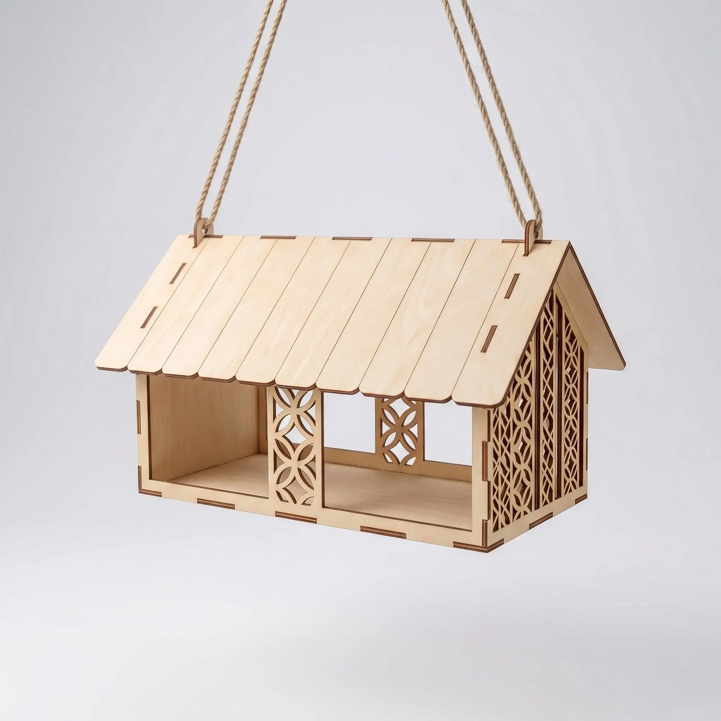 Wooden birdhouse with decorative cutouts on a white background