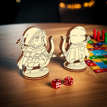 Laser cut archer RPG miniatures shown front and back, wooden tabletop figures placed near dice and board game tiles