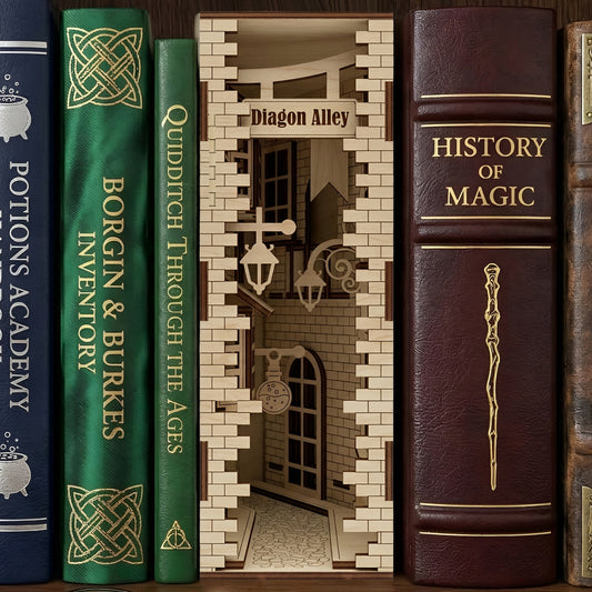 Detailed laser-cut wooden Book Nook Alley diorama depicting a magical cobblestone street, nestled between wizard-themed books on a dark wooden shelf background.