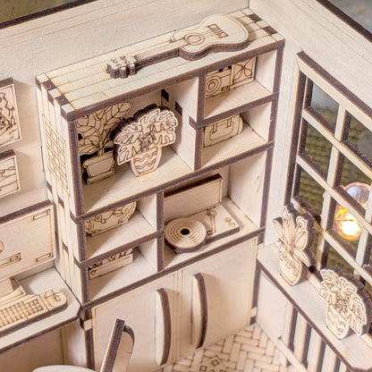 Miniature wooden bookshelf with guitar, houseplants and decor inside a cozy dollhouse bedroom diorama, laser cut file template for book nook craft