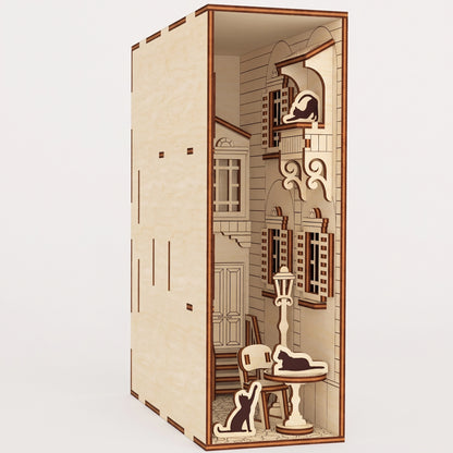 A detailed, unlit miniature French yard book nook crafted from laser cut plywood, showing its architectural depth.