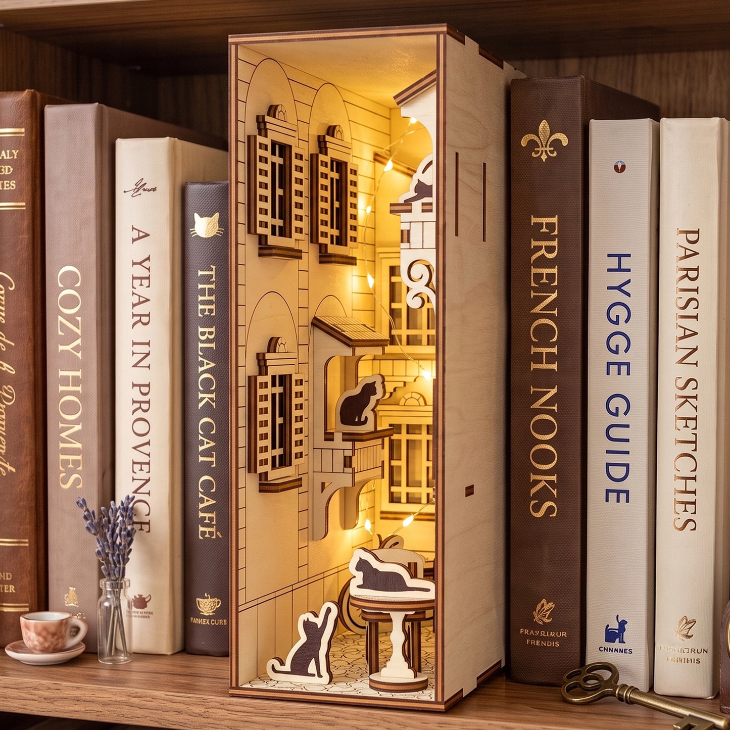 An illuminated laser cut plywood French yard book nook displayed on a shelf surrounded by a collection of books.