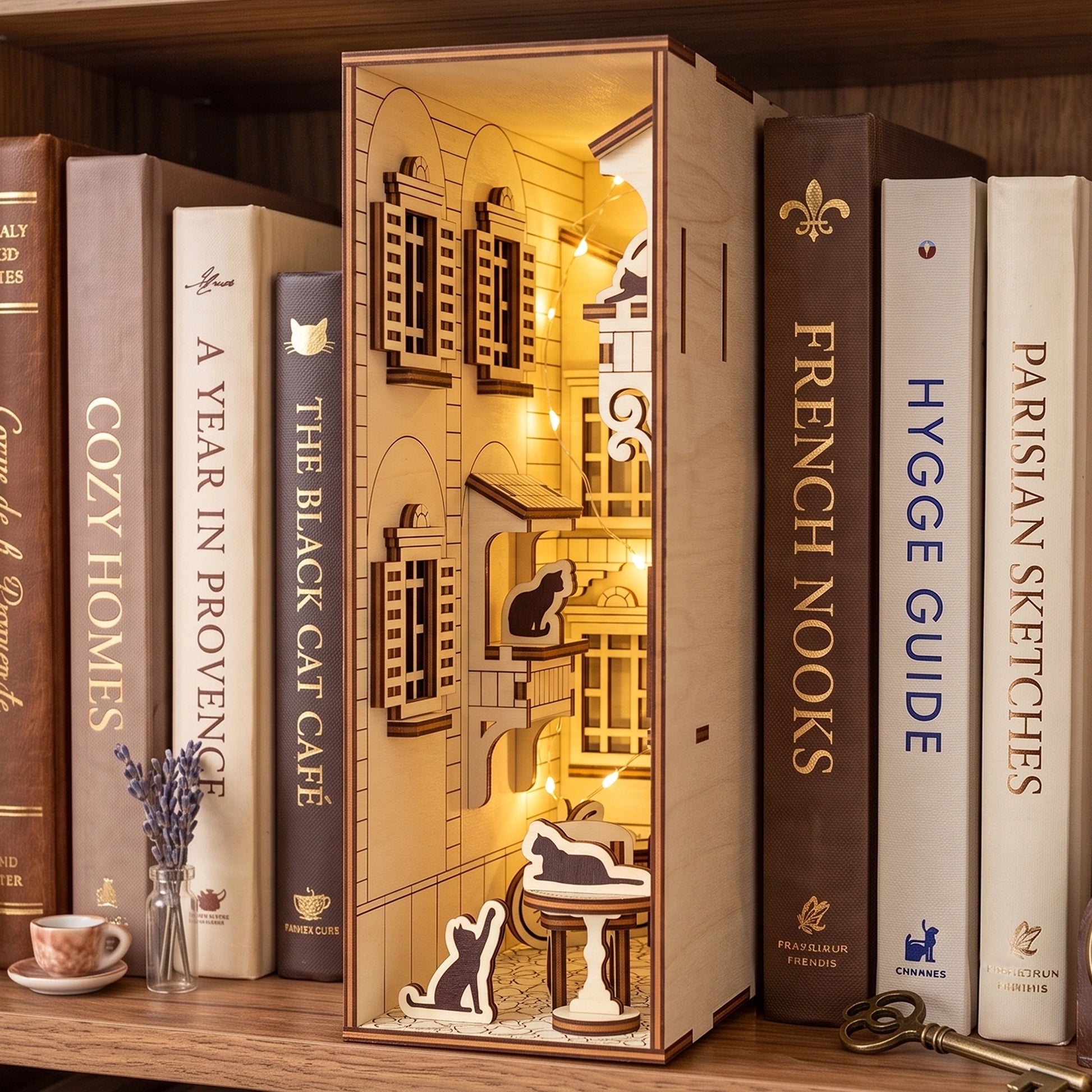 An illuminated laser cut plywood French yard book nook displayed on a shelf surrounded by a collection of books.