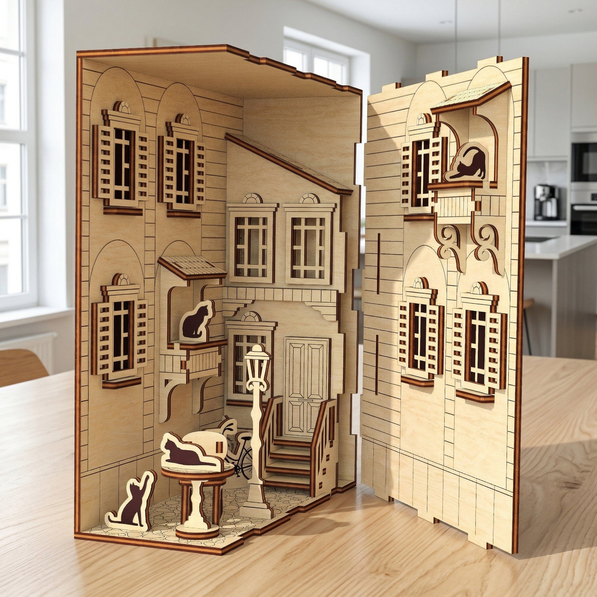 An opened laser cut wooden Book Nook French Yard revealing miniature balconies, shutters, and cat silhouettes, placed on a wooden table with a bright kitchen background.