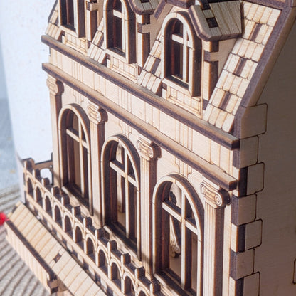 Side angle of the laser cut wooden book nook showing upper arched windows, balcony trim, and dormer windows on the roof