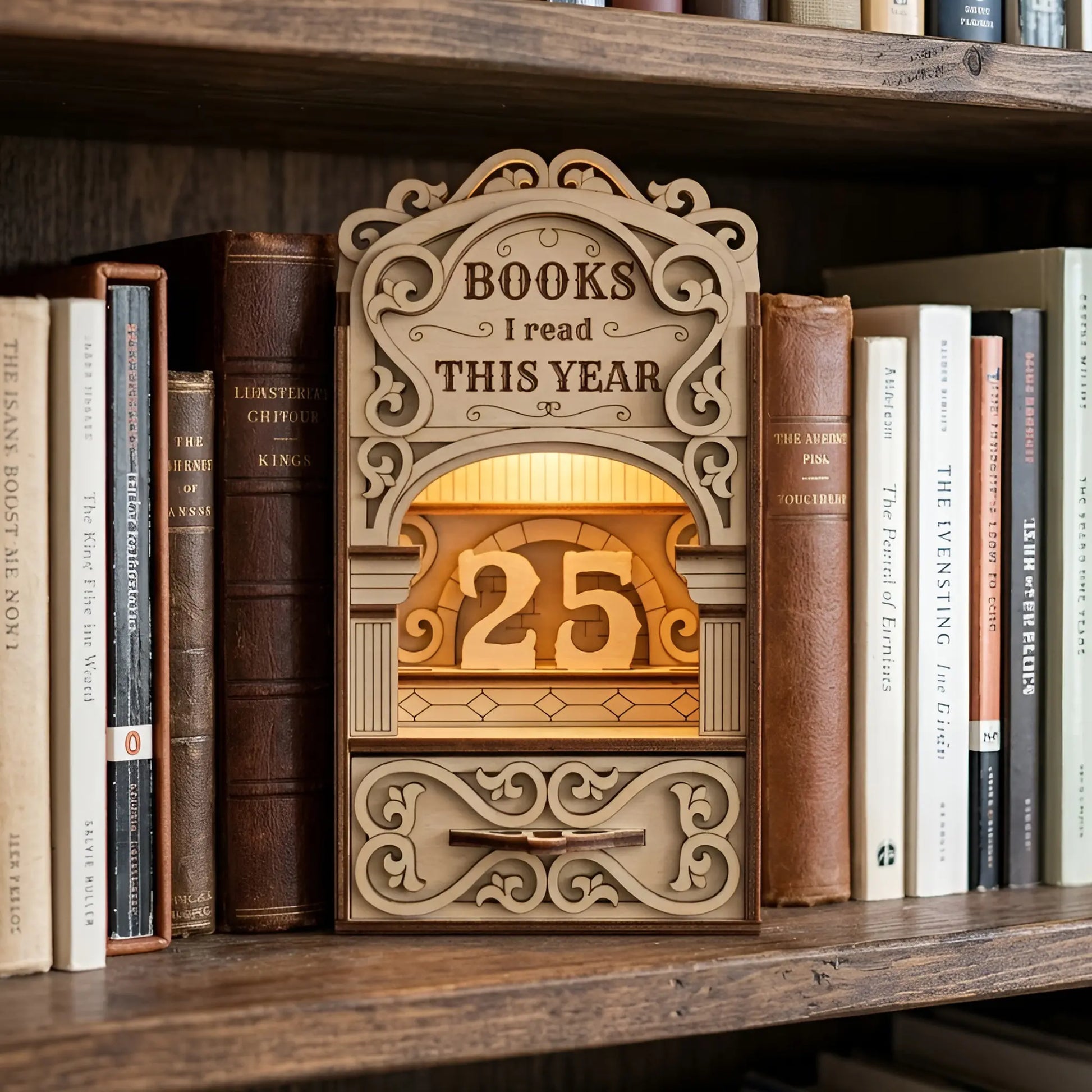 Wooden laser cut “Books I Read This Year” reading tracker book nook displayed on a bookshelf, featuring ornate scroll details, warm lighting, and number counter blocks.