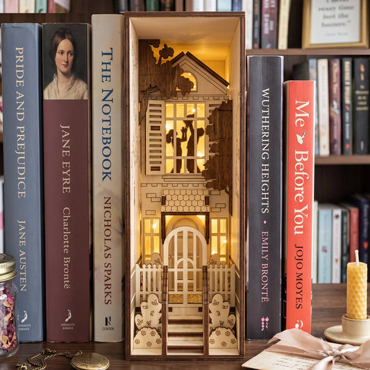 Lit laser-cut birch plywood romantic house book nook on a shelf with classic books, warm lights, and a silhouette couple.