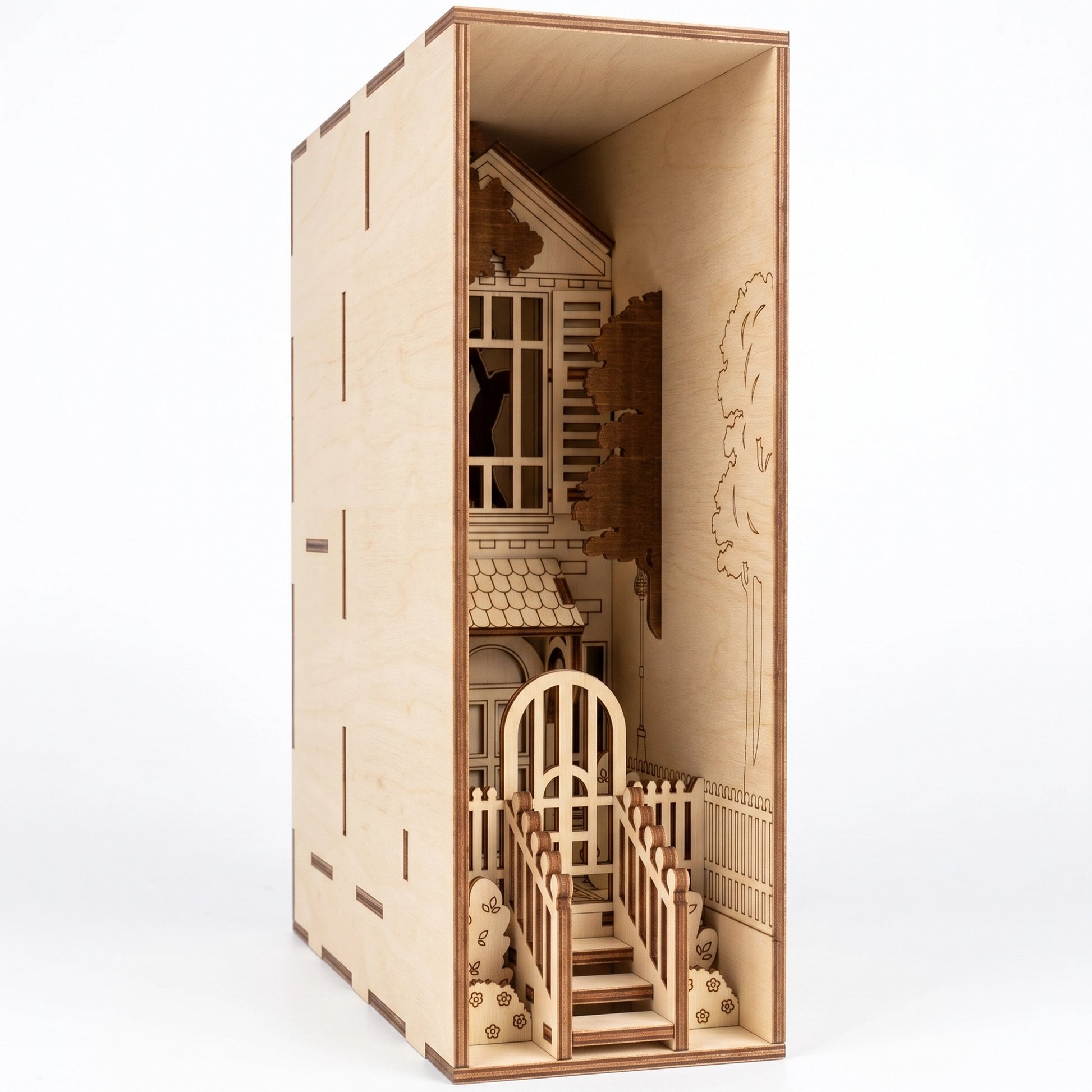 Close-up of a laser-cut birch plywood romantic house book nook featuring stairs, a gateway, and dark burnt edges.