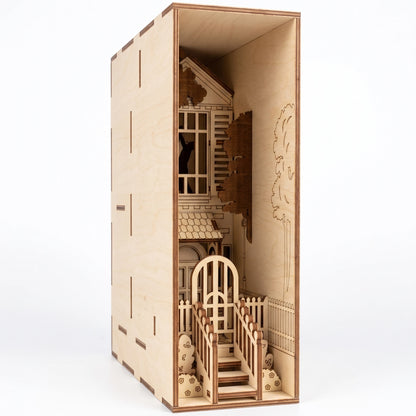 Close-up of a laser-cut birch plywood romantic house book nook featuring stairs, a gateway, and dark burnt edges.