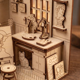 Wooden laser cut book nook model of an artist's studio with furniture and decor.