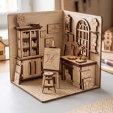 Wooden laser cut book nook model of an artist workshop room with furniture and decor on a light surface.
