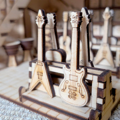Close-up of tiny laser-cut wooden guitars on stands inside the music store book nook diorama