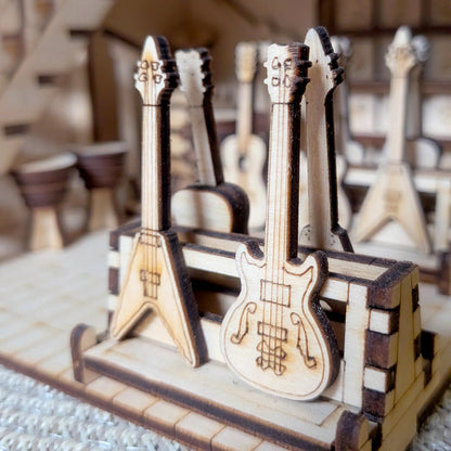 Close-up profile of miniature wooden electric guitars in a rack inside a laser cut plywood music shop model kit.