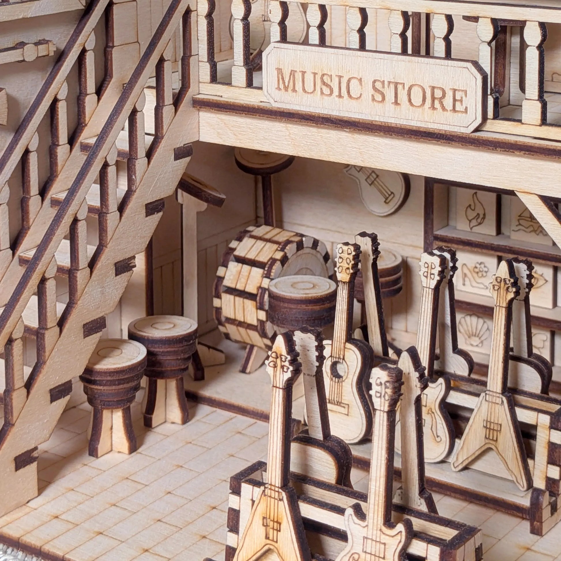 Ground floor view of a laser cut plywood miniature music shop, showcasing racks of tiny guitars and a bongo drum.