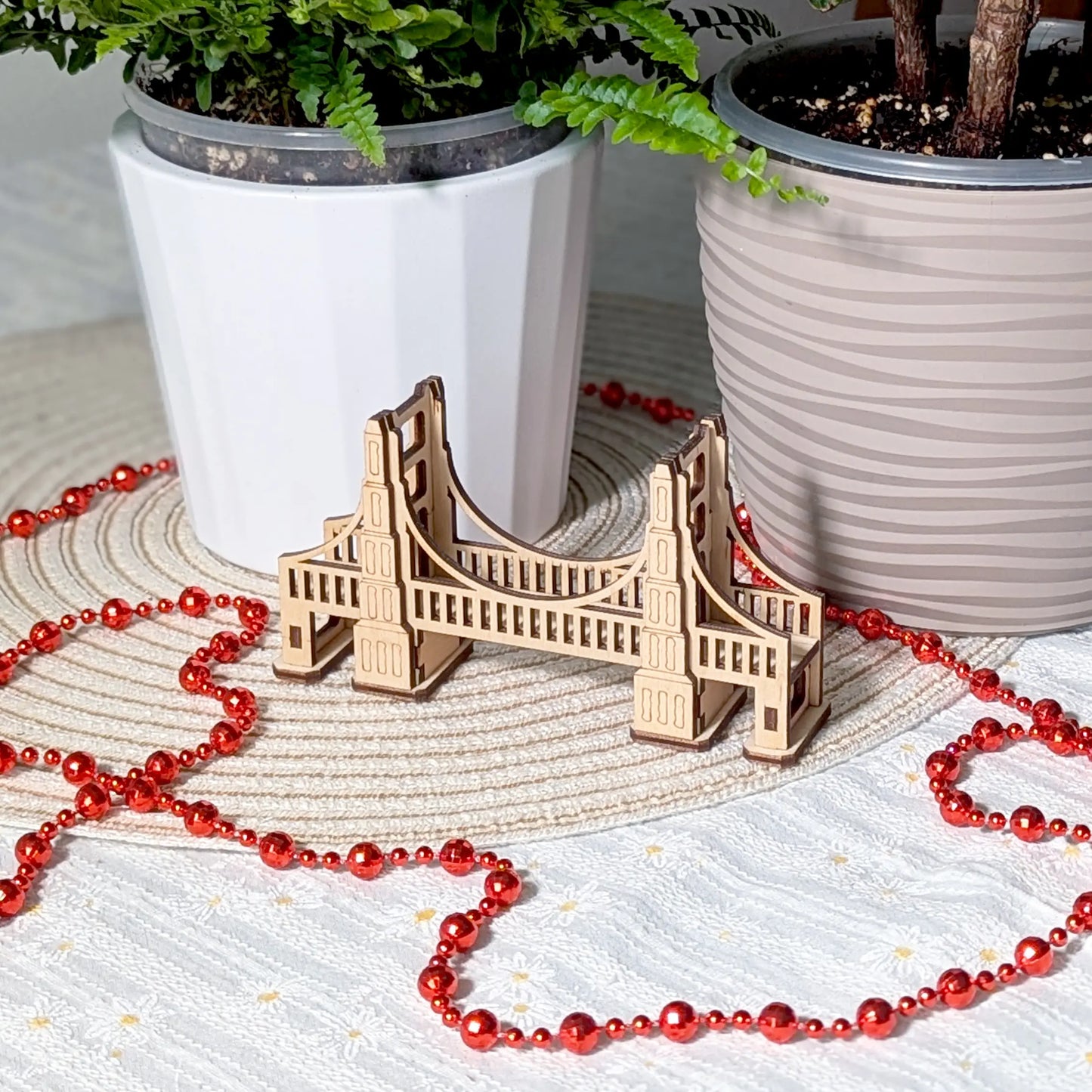 Perspective view of an arched tabletop terrain bridge of laser cut plywood. Features detailed side railings and wood planks