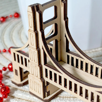 Close-up macro view of a miniature fantasy bridge of laser cut plywood, showing clean burnt edges and fine engraved wood grain