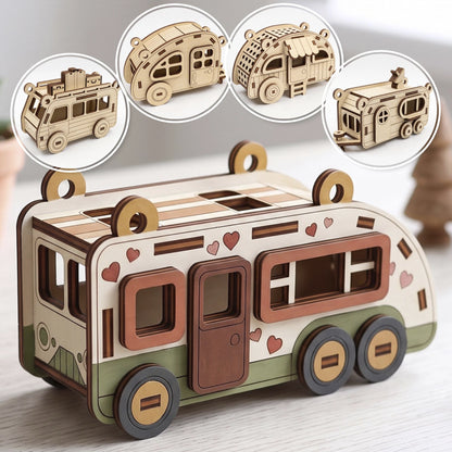Painted laser cut plywood camper model with hearts on table with four round insets showing other wooden toy trailers.