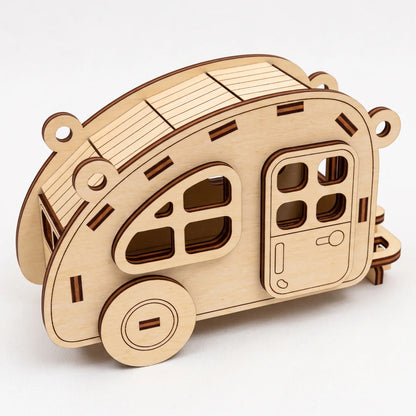 Natural laser cut plywood vintage teardrop camper trailer model with side door and roof slats over white background.