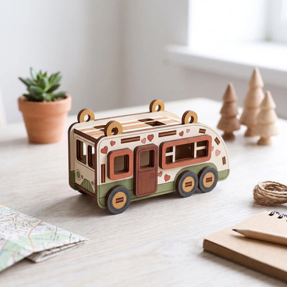 Painted laser cut plywood camper van miniature on desk beside travel map, pencil notebook, and small wooden trees.