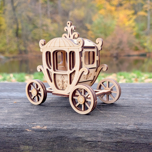 Close-up side view of the wooden laser-cut carriage model, highlighting the ornate curves, engraved patterns, and layered wood construction