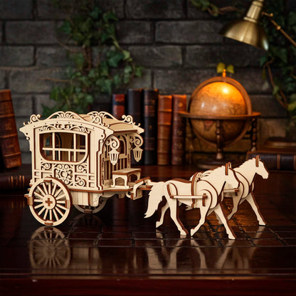 Highly detailed laser cut wooden plywood model of a vintage horse-drawn carriage or ornate wagon being pulled by two standing wooden horses, set on a glossy dark wood desk with a globe, stacked books, and brick wall in the background.