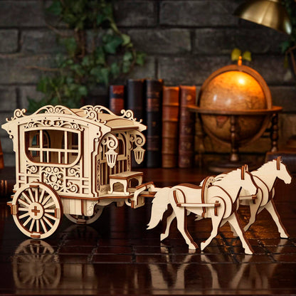 Highly detailed laser cut wooden model of a vintage horse-drawn carriage or ornate wagon being pulled by two standing wooden horses, set on a glossy dark wood desk with a globe, stacked books, and brick wall in the background.