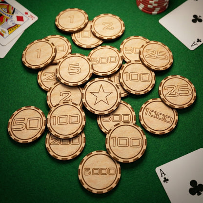 Close-up overhead shot of a pile of laser-cut wooden gambling tokens. A star-engraved chip is centered among various denominations like 100, 500, and 5000. Posed on green felt with playing cards and standard poker chips for size comparison.