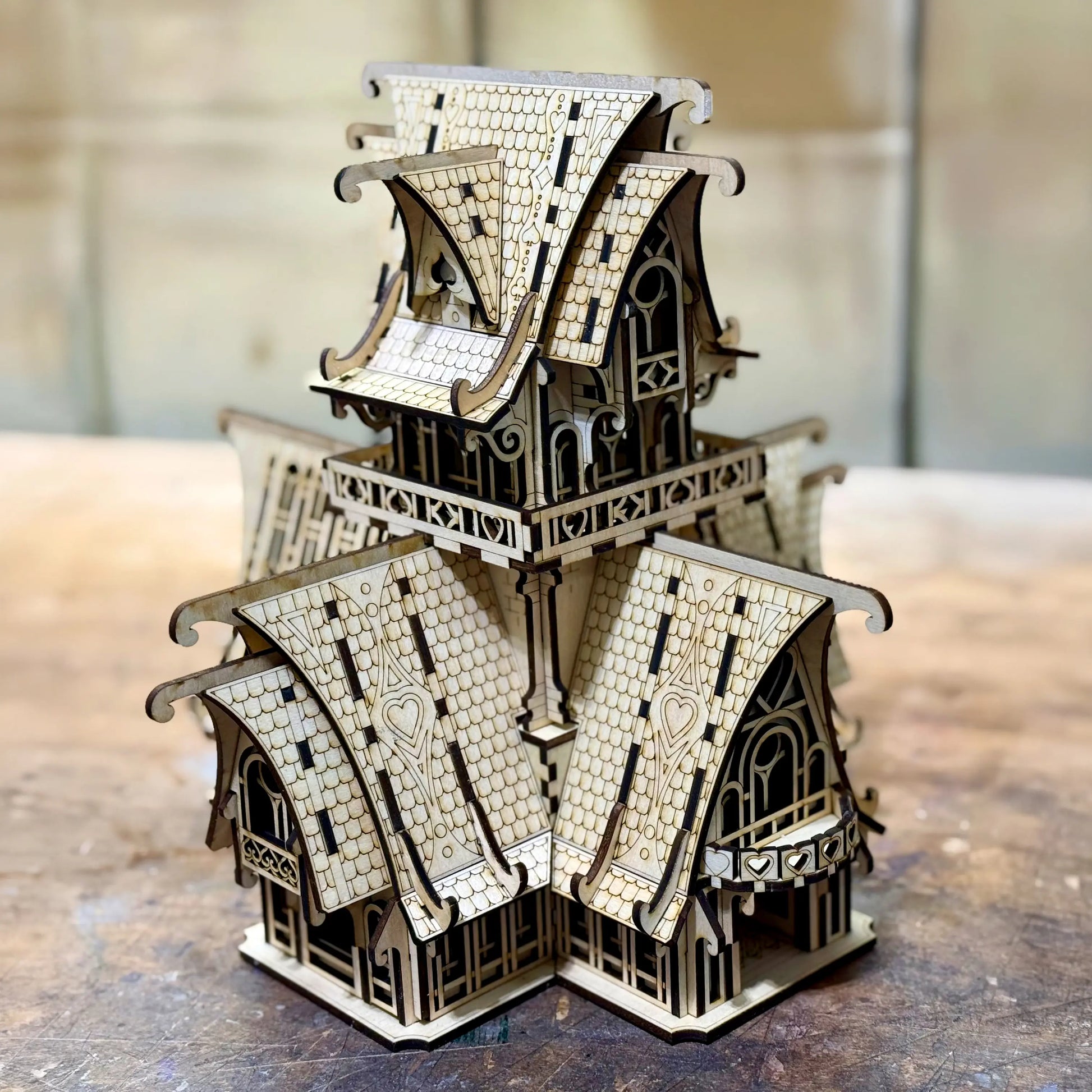 Detailed fantasy castle of laser cut plywood. Features tall conical towers, battlements, and intricate engraved stonework