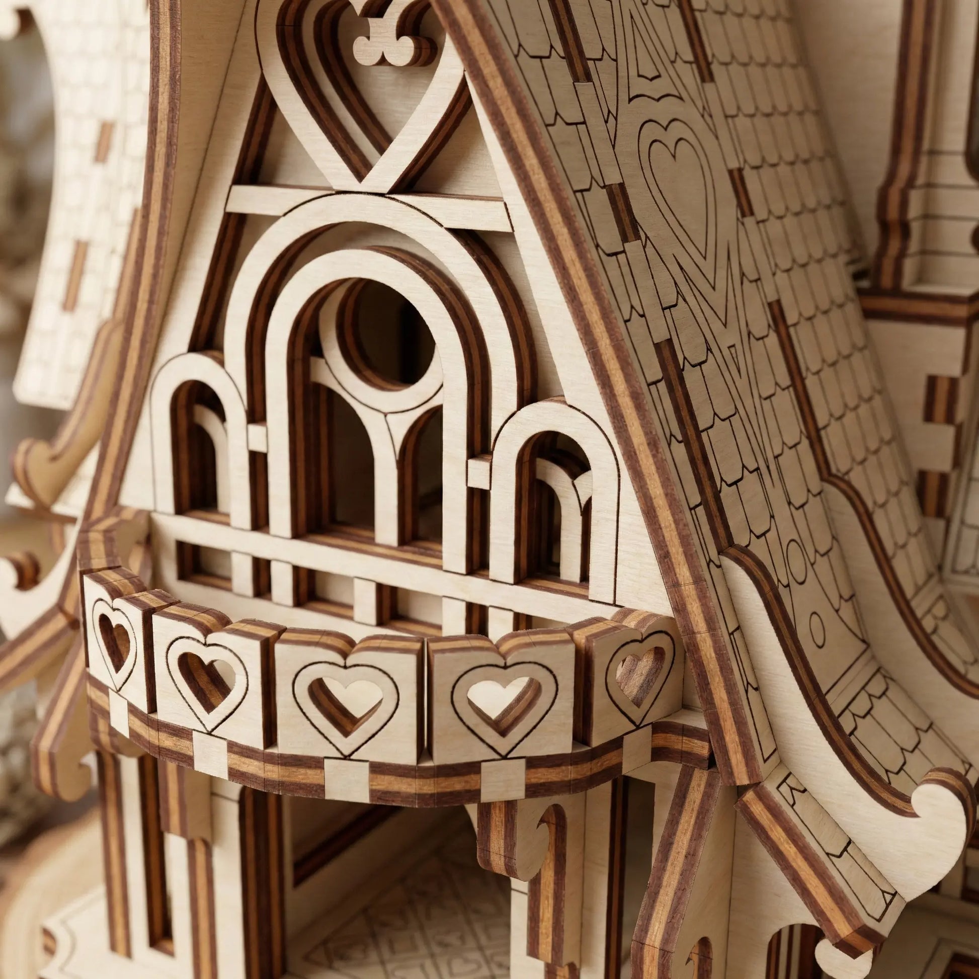 Wooden laser cut model of a detailed architectural structure with decorative elements.