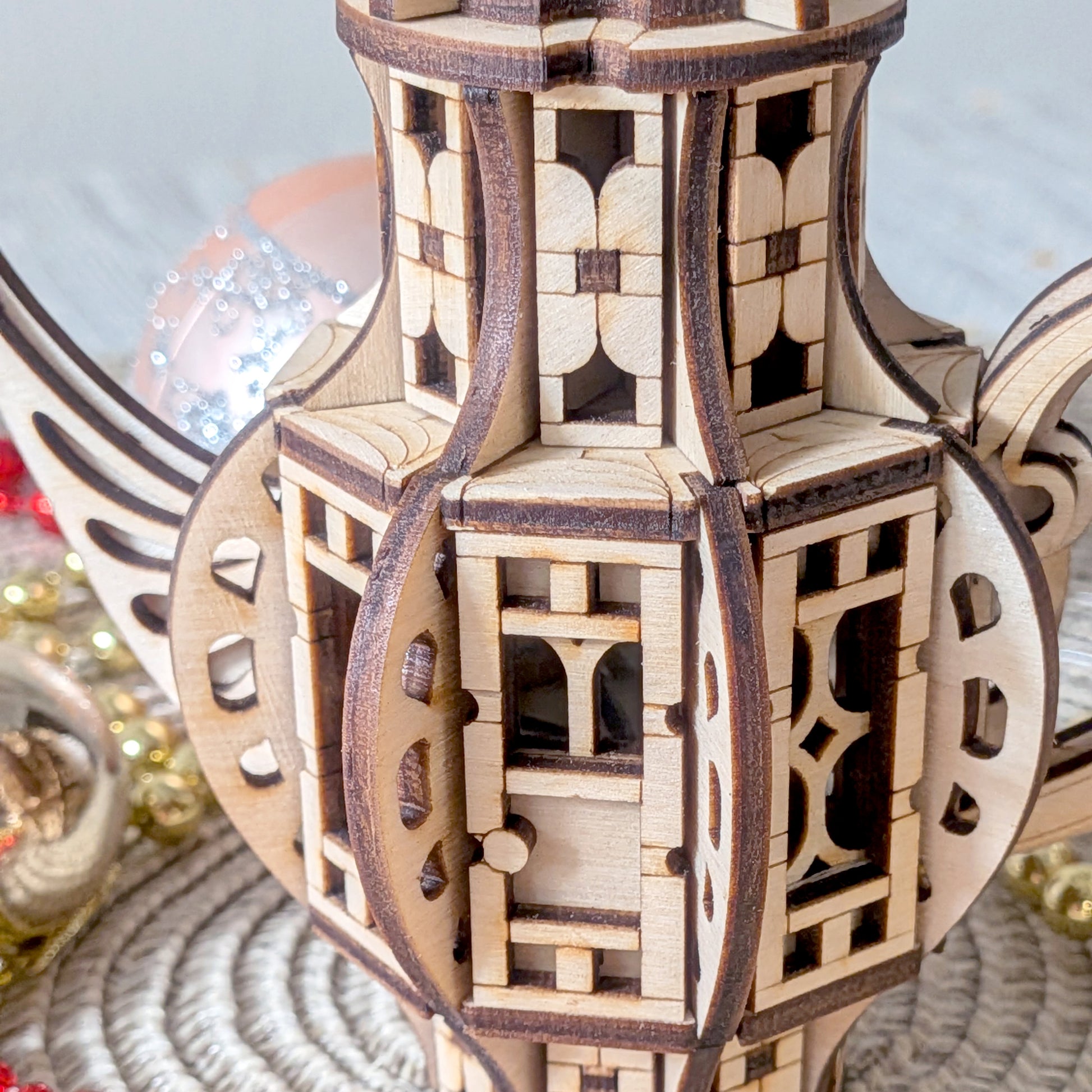 Close-up detail of the laser cut wooden teapot fairy house panels, showing layered wood construction and ornamental window cutouts