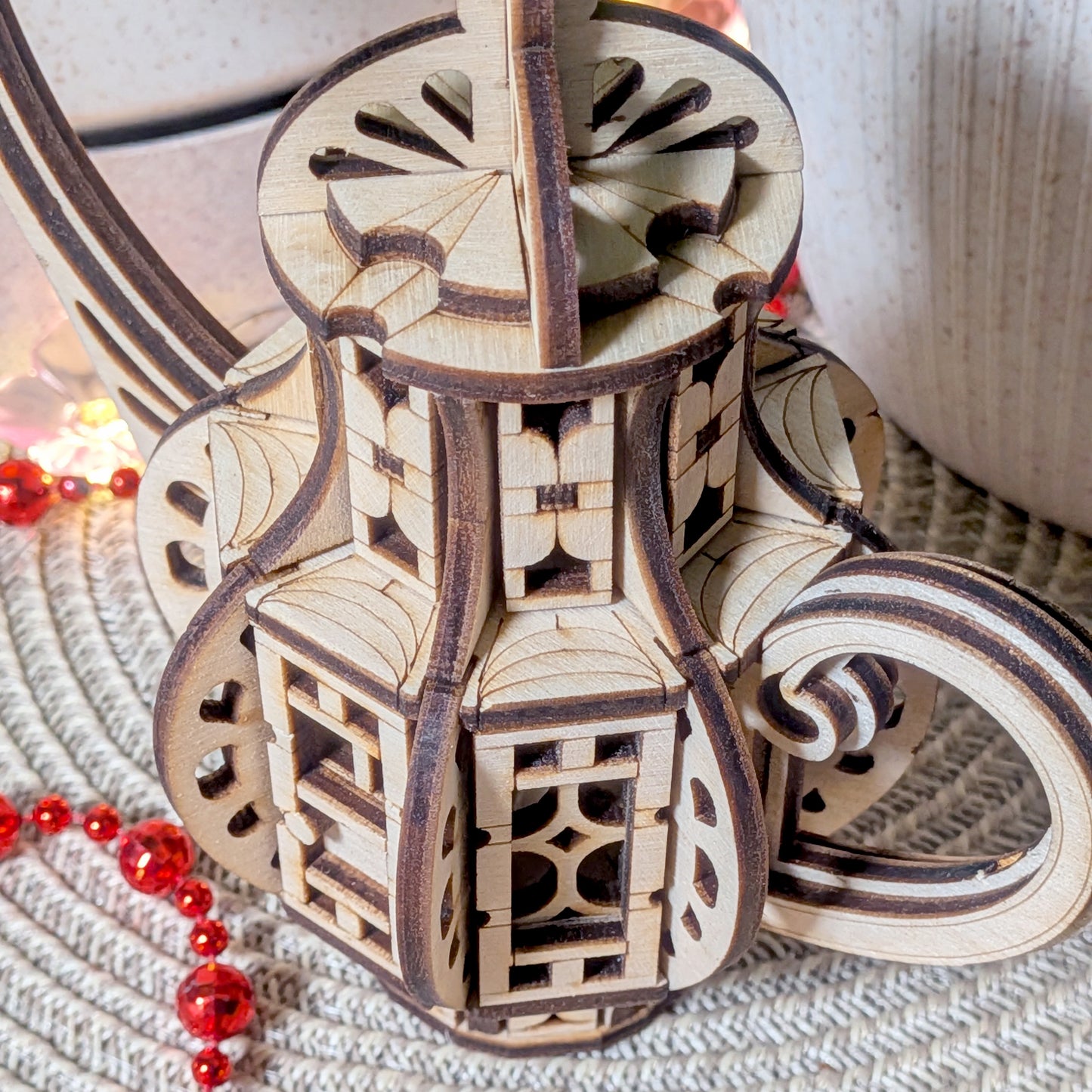 Close-up view of the curved handle and detailed layered wood structure of the laser cut teapot fairy house, highlighting intricate cut patterns.