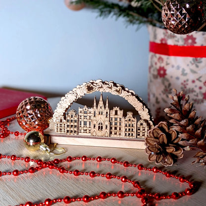 Wide festive product photography of a cozy tabletop winter village arch display beautifully made from fine laser cut plywood.
