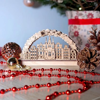 A straight eye-level product shot of a holiday town arch centerpiece beautifully crafted from layered laser cut plywood.