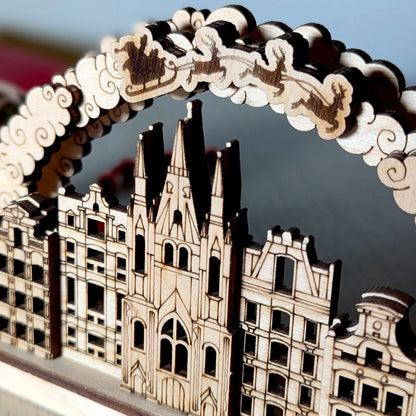 Detailed macro close-up of engraved Santa sleigh and cathedral facade on a Christmas arch made from fine laser cut plywood.
