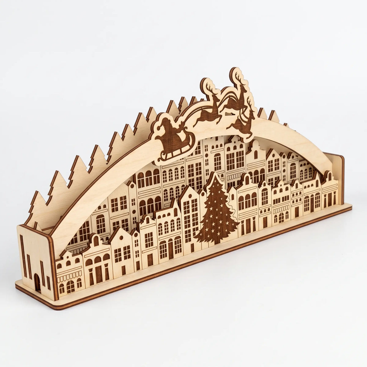 Natural unfinished laser cut plywood Christmas town arch diorama with Santa sleigh and reindeer on plain white backdrop.