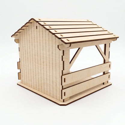 Rear three-quarter perspective view of empty laser cut plywood nativity barn showing slatted plank roof on white.