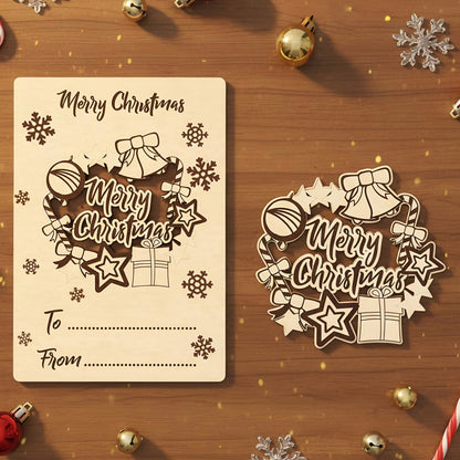 Wooden laser cut Christmas card featuring an intricate "Merry Christmas" wreath design with bells, stars, gifts and snowflakes, shown with its matching gift tag on a warm wooden background.