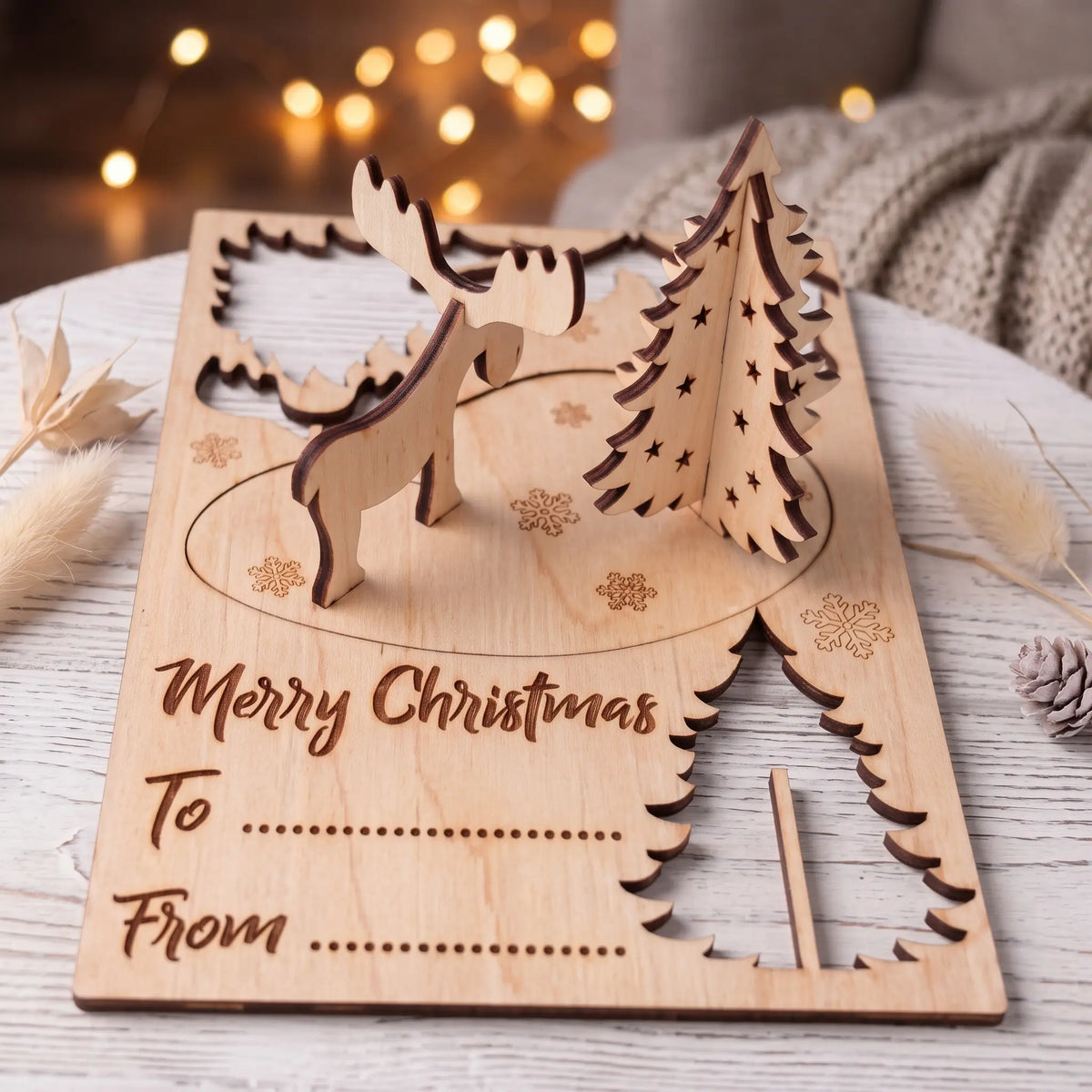 Laser cut plywood Christmas card with pop out 3D tree and moose assembled on card base with To and From.