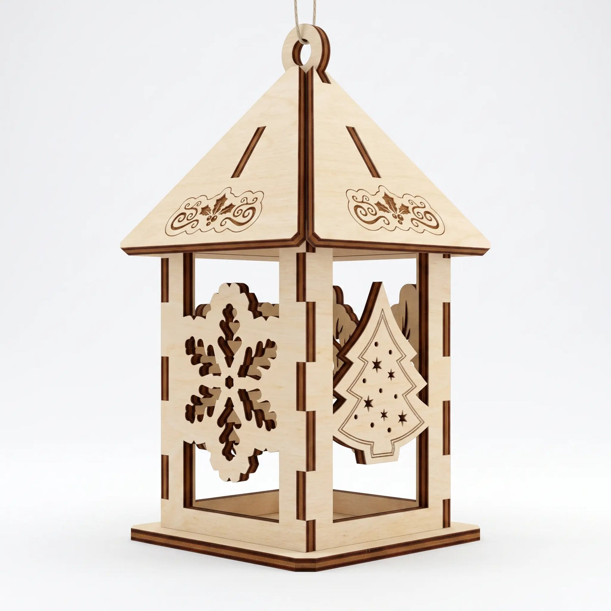 Laser cut plywood hanging lantern with silhouette of snowflake and Christmas tree on plain backdrop.