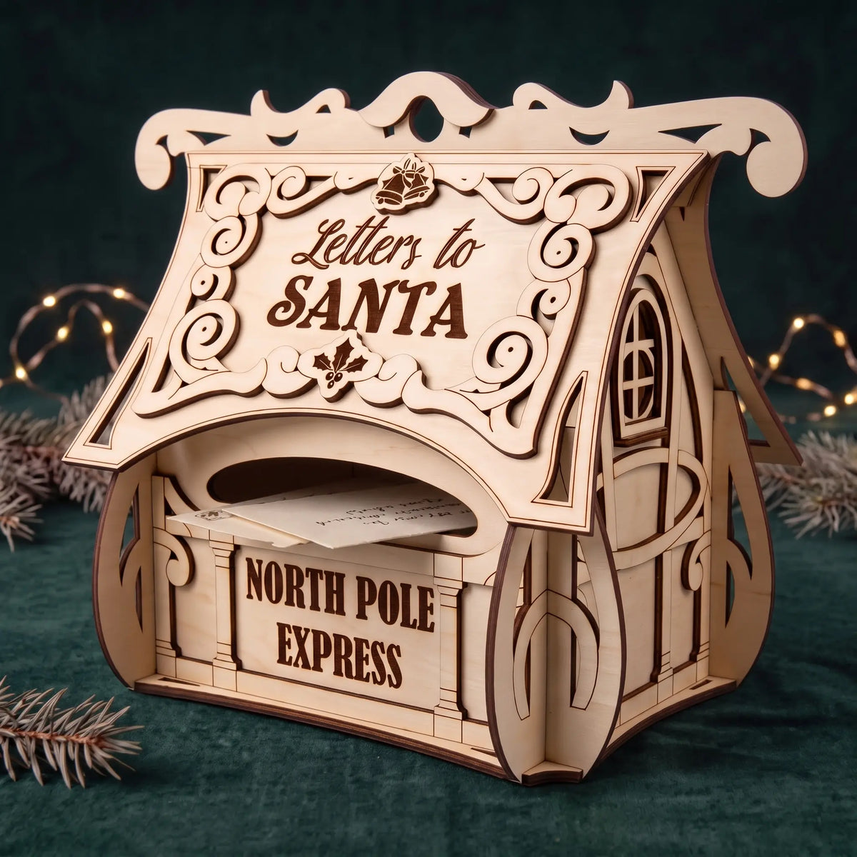 Laser cut plywood Letters to Santa mailbox with inserted envelopes, set on green velvet with pine and fairy lights.