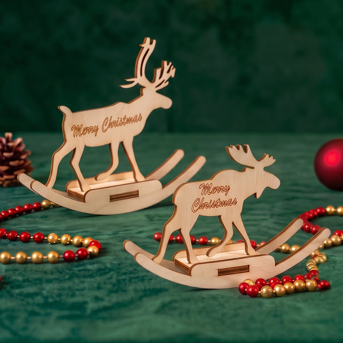 Pair of rocking reindeer and moose of laser cut plywood displayed on dark green velvet with red beads.